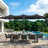 Patioslife black patio umbrella with LED lights over outdoor dining set beside pool and garden