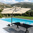 Patioslife cream cantilever parasol with LED lights over poolside dining set and garden view