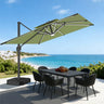 Patioslife sage green cantilever parasol with LED lights over garden dining set by the coast
